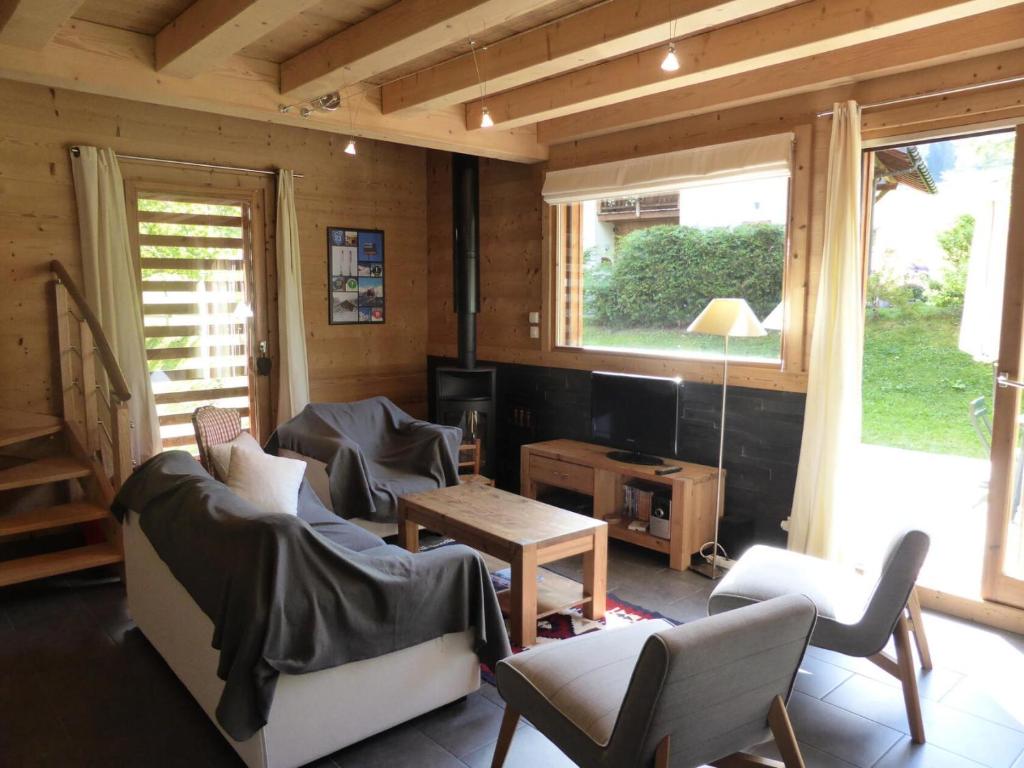 a living room with a couch and chairs and a tv at Chalet Champelet - Chalets pour 8 Personnes 33 in Les Contamines-Montjoie