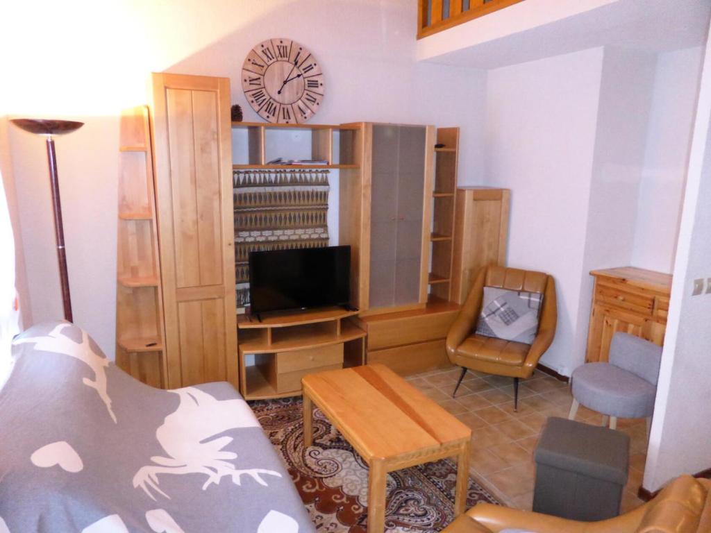 a living room with a couch and a clock on the wall at Résidence Schuss - 3 Pièces pour 8 Personnes 35 in Les Contamines-Montjoie