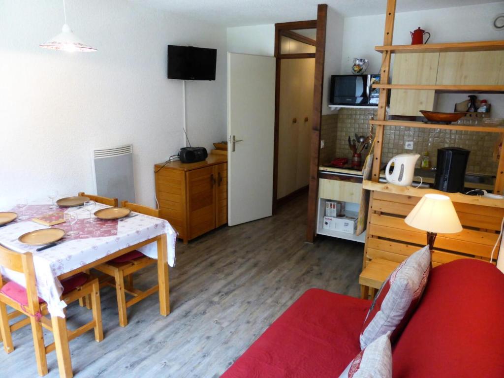ein Wohnzimmer mit einem Tisch und einer Küche in der Unterkunft Résidence Le Brulaz - Studio pour 5 Personnes 47 in Les Contamines-Montjoie
