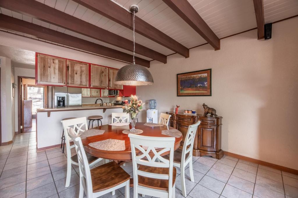 een keuken en eetkamer met een houten tafel en stoelen bij Grande View Condo: 3 Bedroom 2 Bathroom Townhome with a Game Room! in Ruidoso