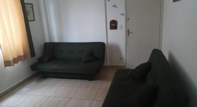 salon z zieloną kanapą i krzesłem w obiekcie Mourão 5 w mieście Praia Grande