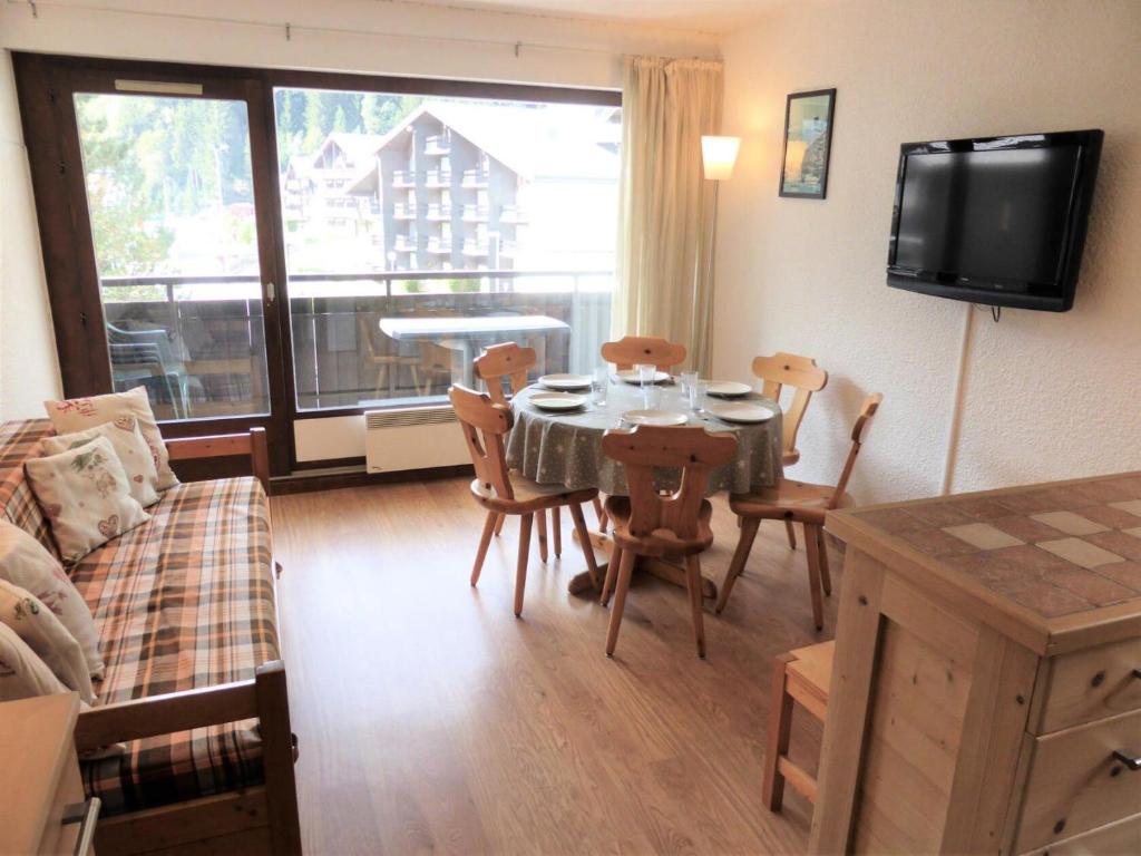 ein Wohnzimmer mit einem Tisch, Stühlen und einem Sofa in der Unterkunft Résidence Rochasset - 3 Pièces pour 6 Personnes 45 in Les Contamines-Montjoie