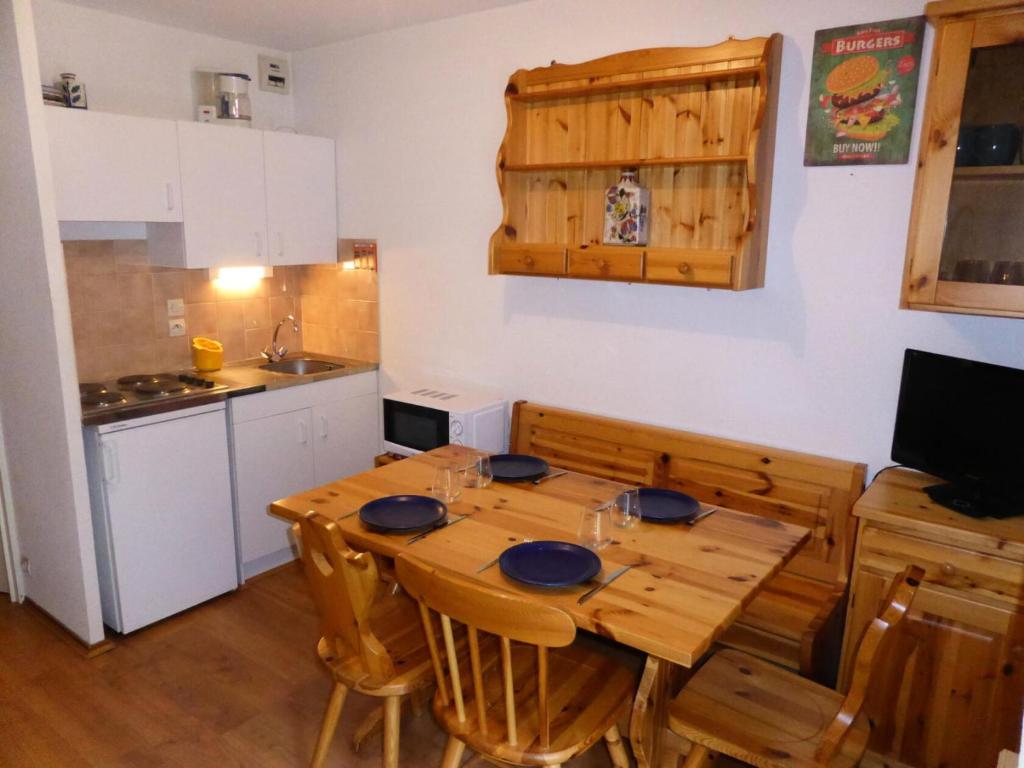 cocina con mesa de comedor de madera con sillas en Résidence L'enclave - Studio pour 4 Personnes 53 en Les Contamines-Montjoie