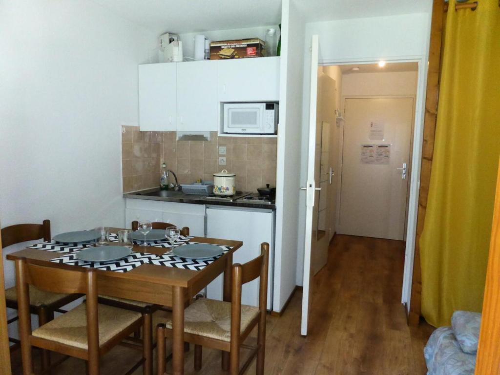 a kitchen and dining room with a table and chairs at Résidence L'enclave - Studio pour 4 Personnes 54 in Les Contamines-Montjoie