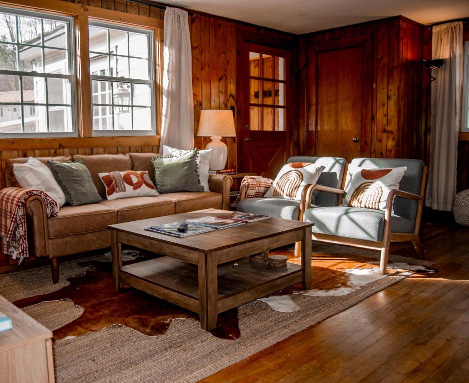 un soggiorno con divano, 2 sedie e tavolo di Birch House: Cozy Cabin 5 min from Okemo a Ludlow