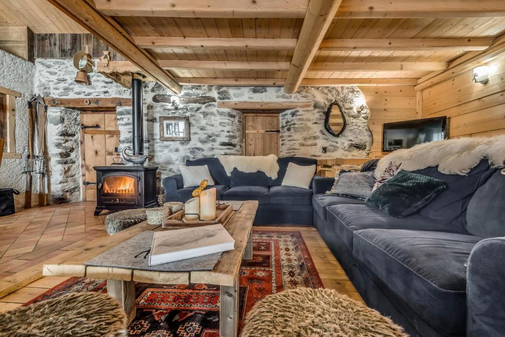 a living room with a blue couch and a fireplace at Chalet Colettine - 7 Pièces pour 12 Personnes 09 in Tignes