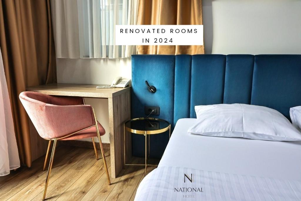 a bedroom with a bed and a desk and a chair at Hotel National in Zagreb