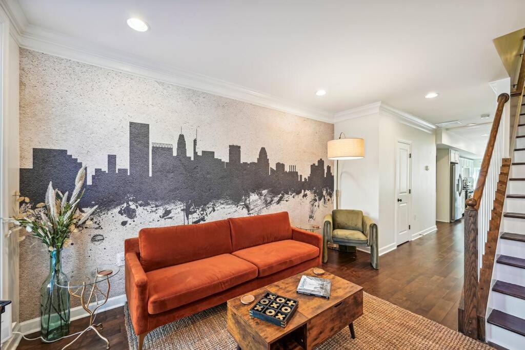 a living room with a couch and a city mural at Federal Hill Luxury + City Charm in Baltimore