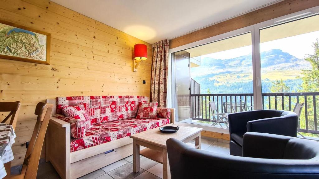 d'un salon avec un canapé et un balcon. dans l'établissement Résidence Les Pleiades - Appartement spacieux et lumineux · Centre station · Balcon · Parking couvert MAE-7355, à Flaine