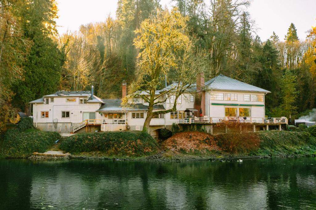 ein großes weißes Haus am Ufer eines Flusses in der Unterkunft Clackamas Riverfront GuestHouse, Sauna & HotTub in Oregon City