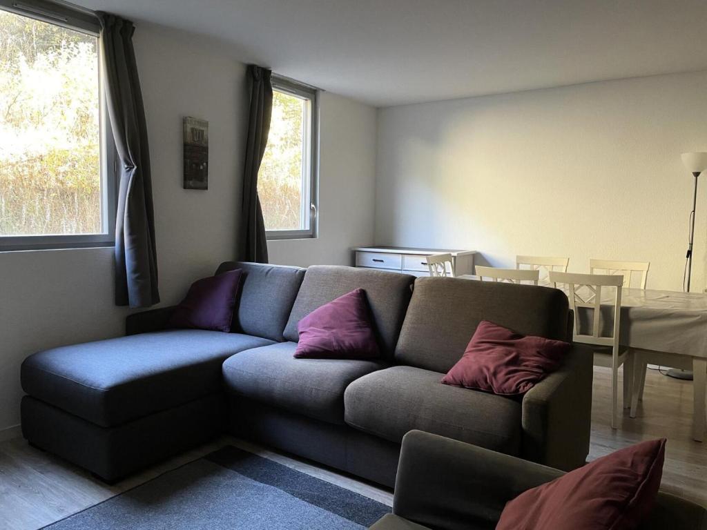 sala de estar con sofá y almohadas moradas en Résidence La Petite Ourse - 3 Pièces pour 6 Personnes 62, en Flaine
