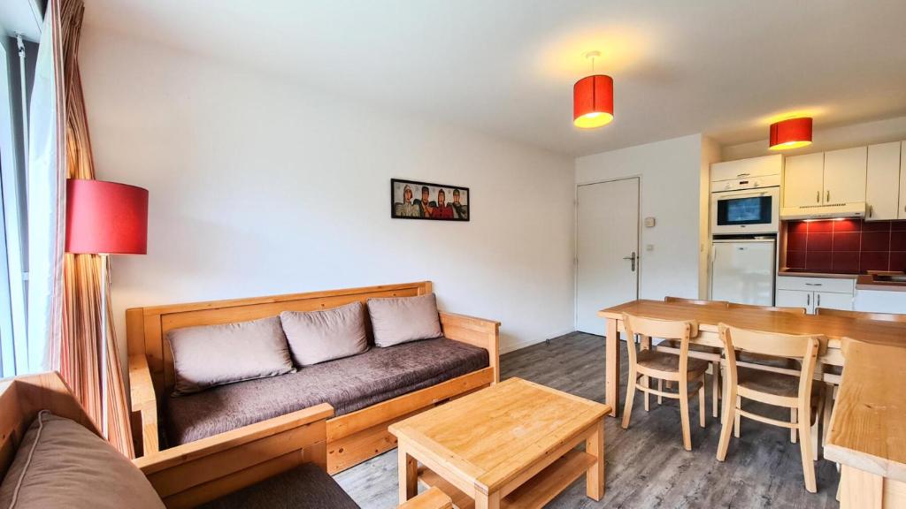 ein Wohnzimmer mit einem Sofa und einem Tisch in der Unterkunft Résidence Les Pleiades - 3 Pièces pour 6 Personnes 81 in Flaine