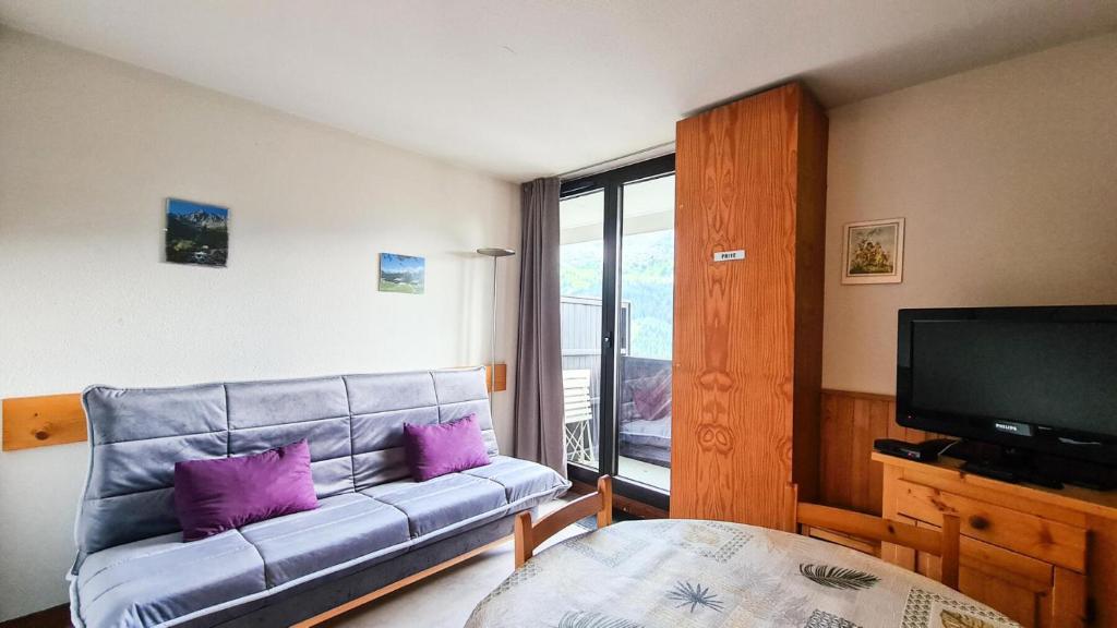 ein Wohnzimmer mit einem Sofa und einem TV in der Unterkunft Résidence Doris - Studio pour 4 Personnes 04 in Flaine