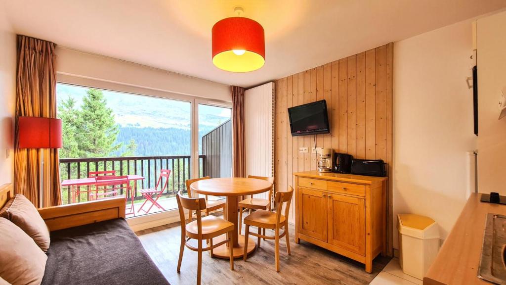 d'un salon avec une table et un balcon. dans l'établissement Résidence Les Pleiades - Appartement lumineux · Centre station · Parking couvert · Balcon MAE-7409, à Flaine
