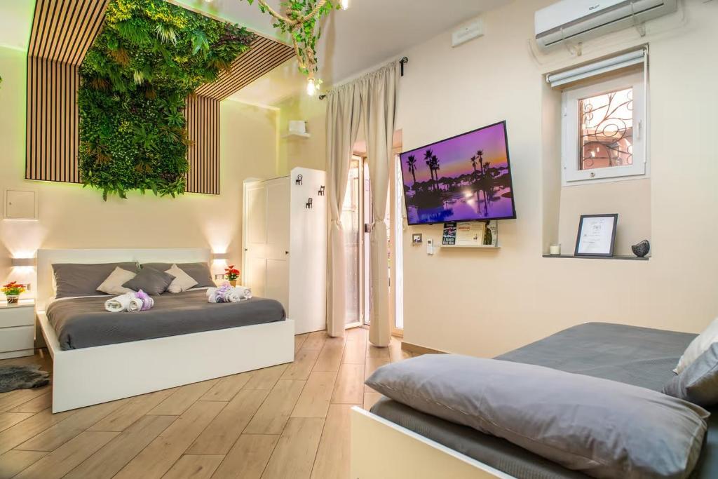 una camera con due letti e una parete verde di Tropical Holiday House a Catania