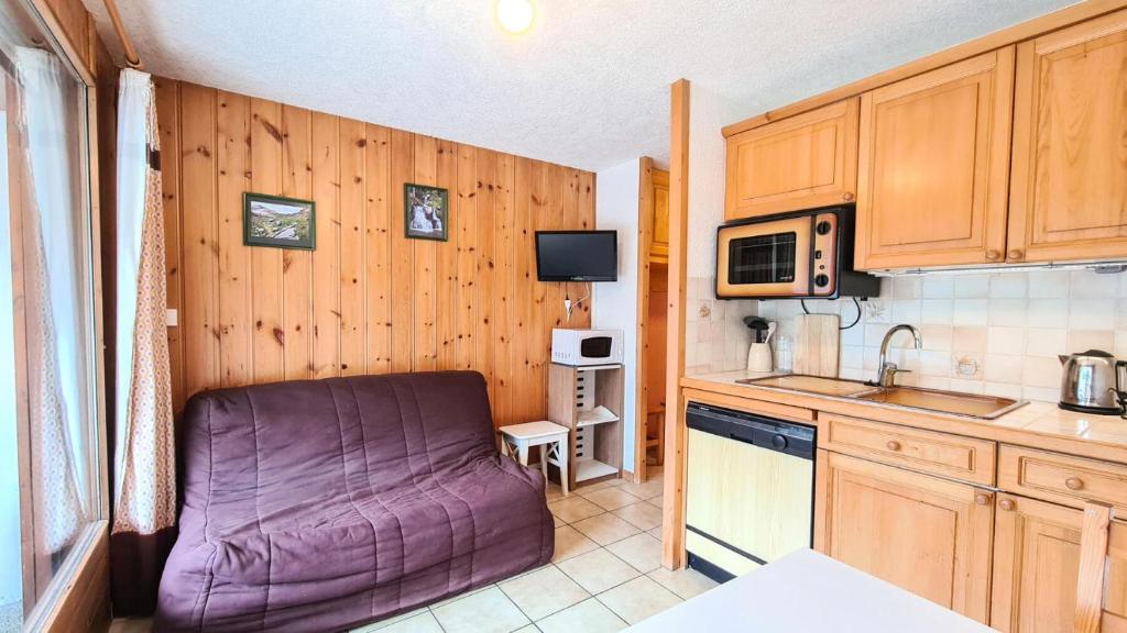 - une petite cuisine avec un canapé violet dans l'établissement Résidence Arche - Studio confortable · Centre station · Terrasse MAE-7414, à Flaine
