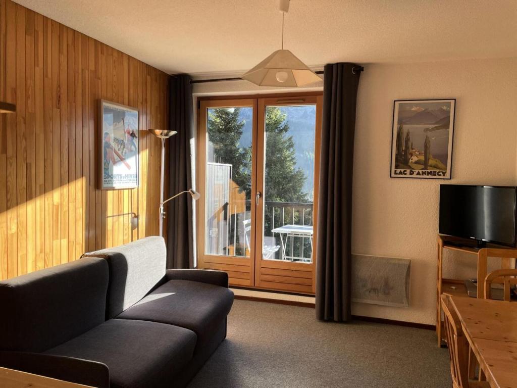 a living room with a couch and a large window at Résidence Pollux - Studio pour 4 Personnes 15 in Flaine