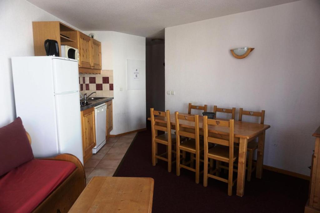 une cuisine avec une table, des chaises et un réfrigérateur dans l'établissement Résidence Cristallines - 2 Pièces cabine 6 personnes MAE-9692, à Orcières