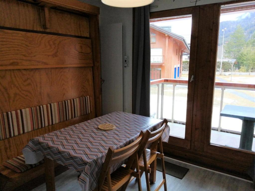 a table and chairs in a room with a window at Résidence Combettes - Studio pour 4 Personnes 34 in Les Contamines-Montjoie