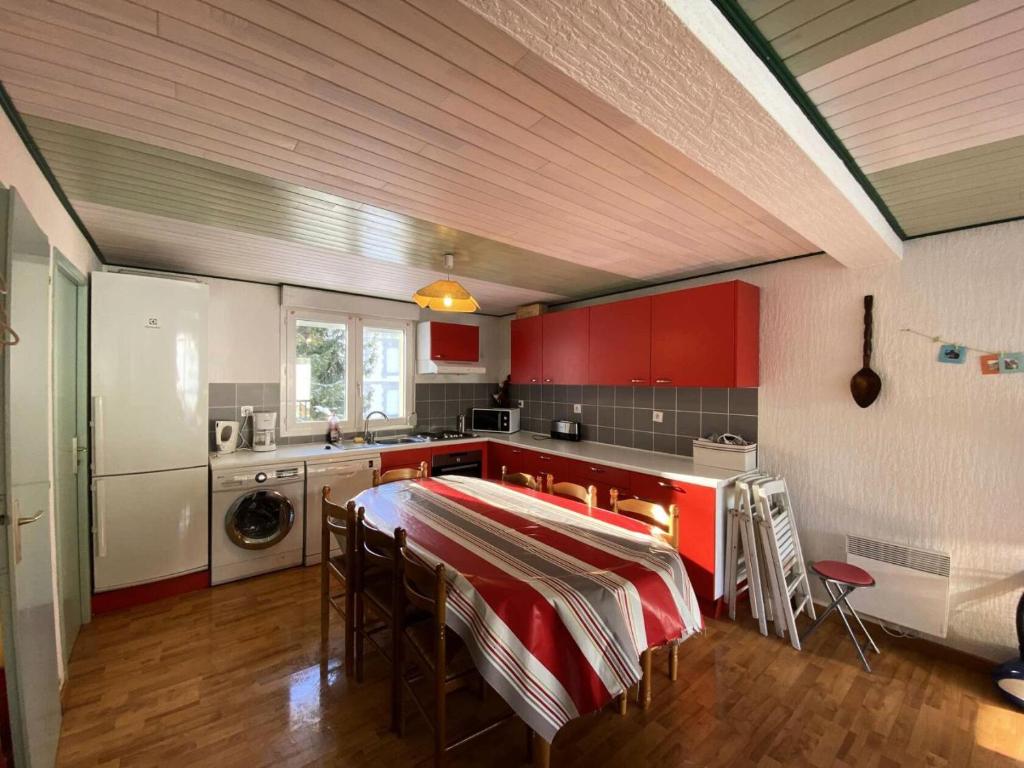 een keuken met rode kasten en een tafel met stoelen bij Résidence Leaney - Pièces 424 in Barèges