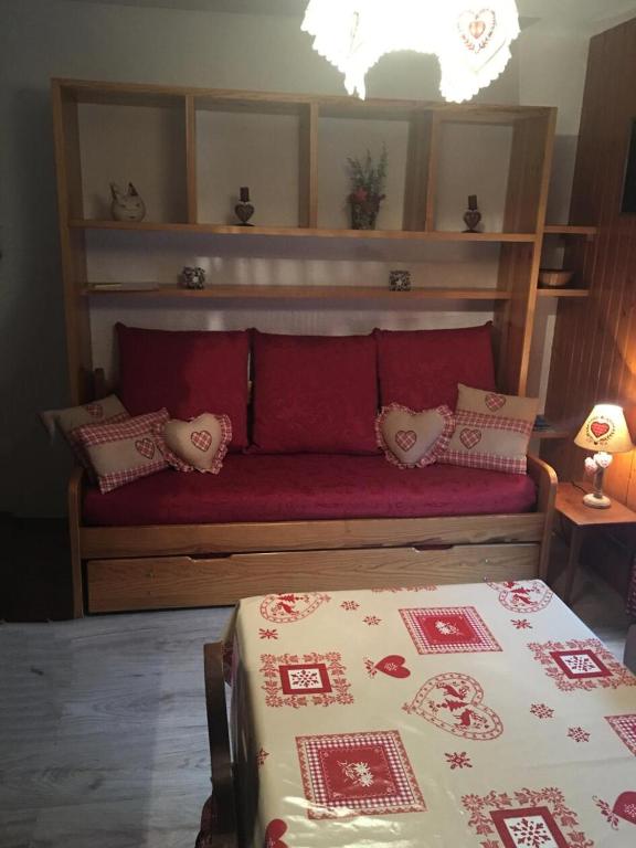 - une chambre avec un lit et un canapé rouge avec des oreillers dans l'établissement Résidence Betelgeuse - Studio cabine 3 personnes exposé est MAE-7844, à Valloire