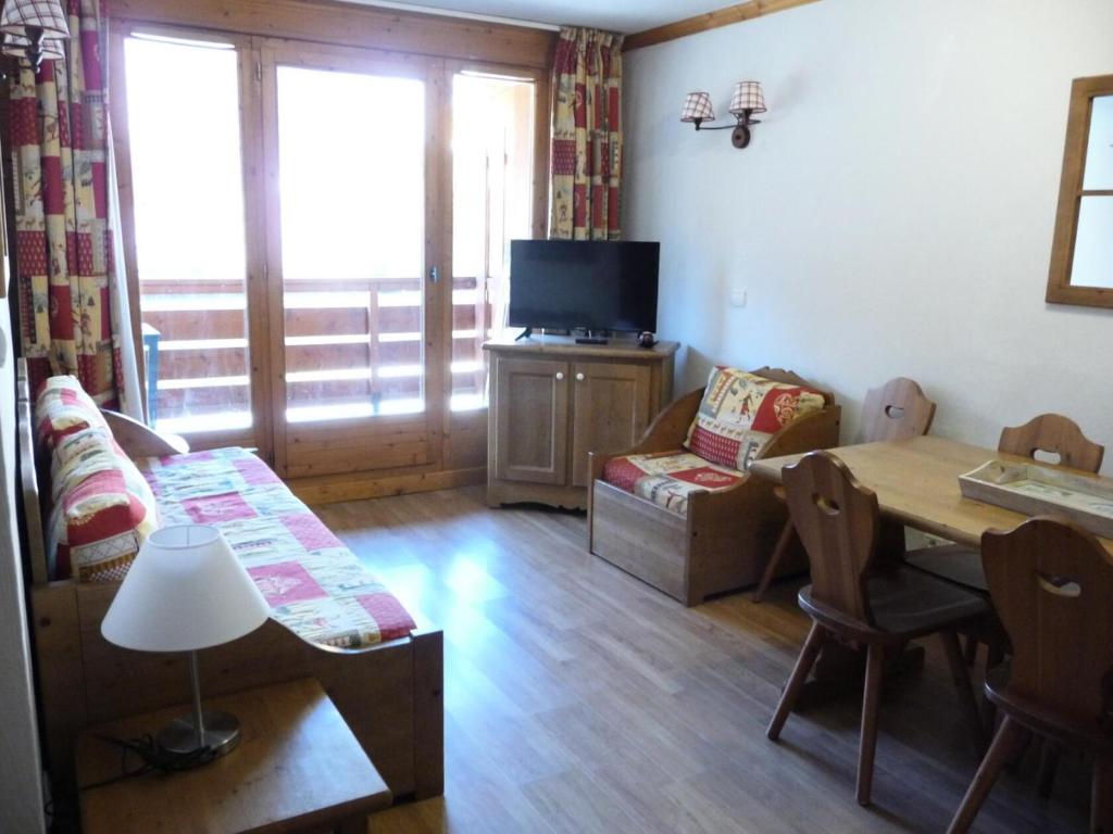a living room with a table and a tv at Ancolie Chalets De La Vallee D'or - 3 Pièces pour 6 Personnes 84 in Valloire