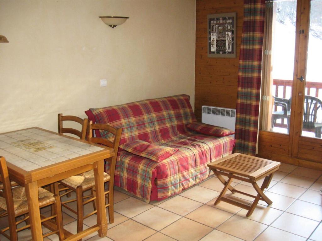 a living room with a couch and a table at Résidence Myosotis Hameau De La Vallee D'or - 2 Pièces pour 4 Personnes 64 in Valloire