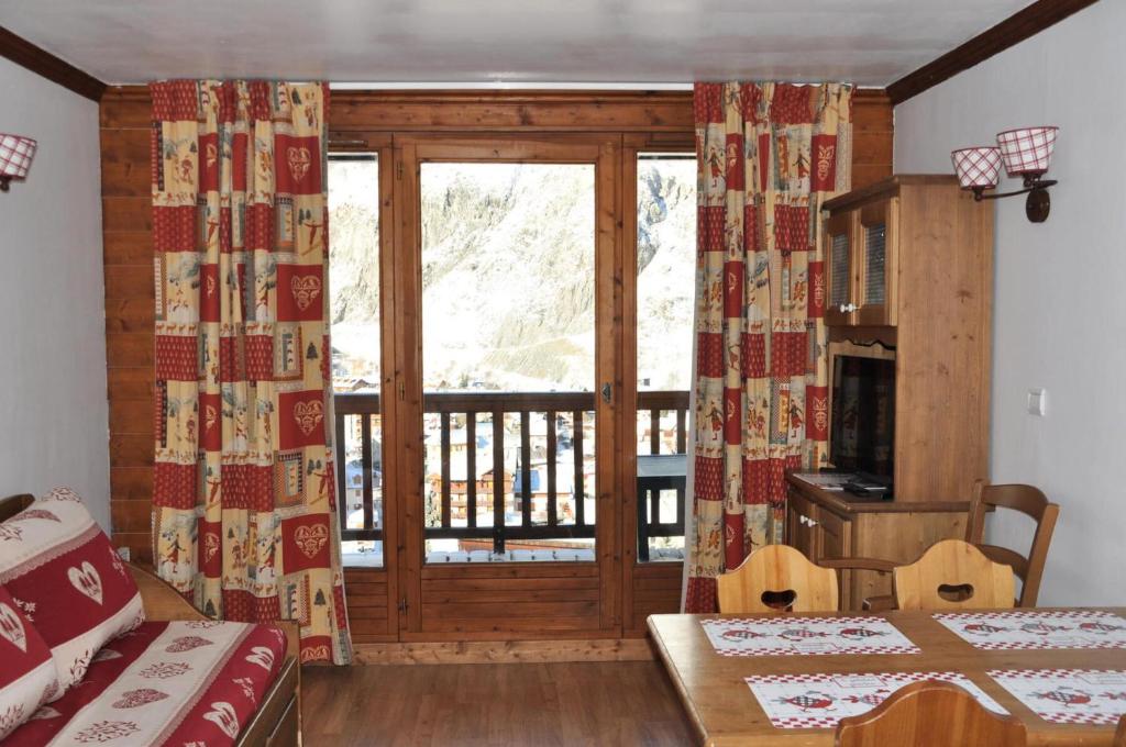 een kamer met een glazen schuifdeur en een balkon bij Résidence Gentiane Hameau De La Vallee D'or - 2 Pièces pour 4 Personnes 74 in Valloire