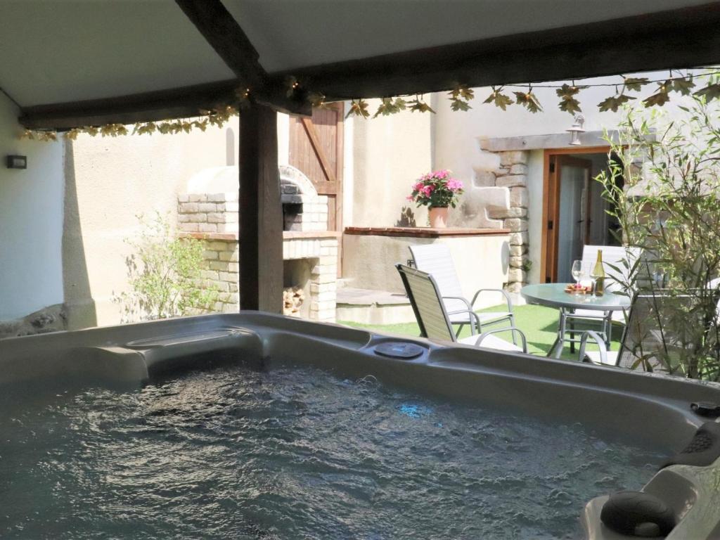 a hot tub on a patio with a table and chairs at 3 bed property in Bovey Tracey 52042 in Bovey Tracey