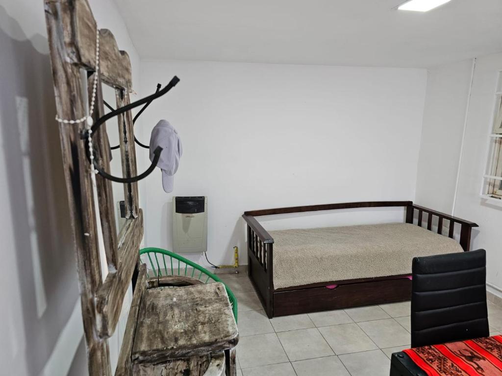 um quarto com uma cama e um banco num quarto em Departamento cómodo y confortable em Rio Grande