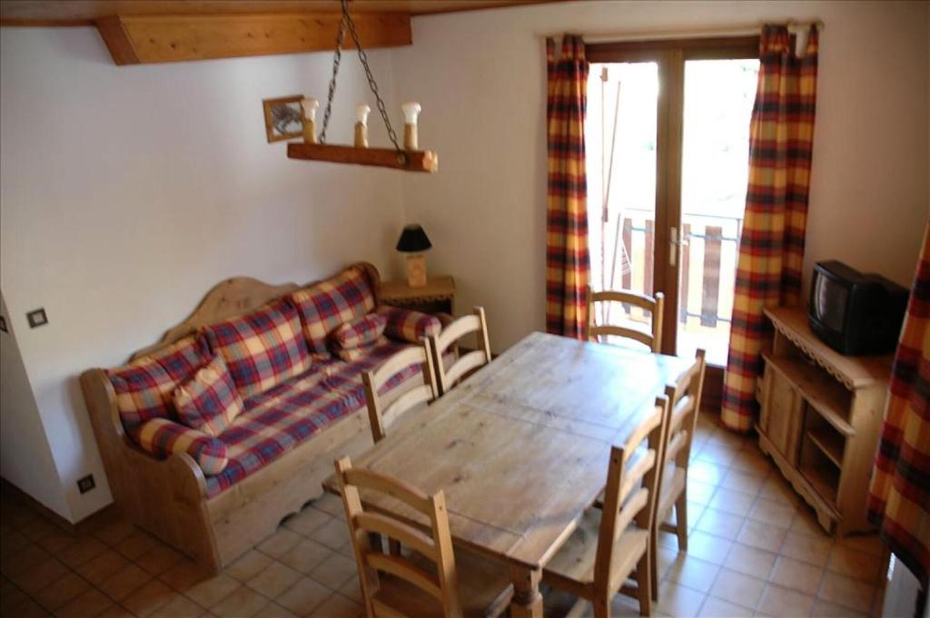a living room with a wooden table and a couch at Résidence Les Alpages - 3 Pièces pour 6 Personnes 74 in Valloire