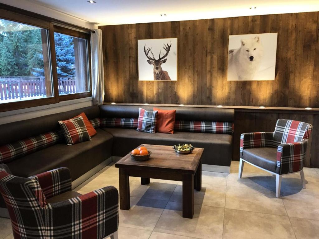 a living room with couches and a table and deer heads at Résidence Les Fermes Du Planet - Pièces 74 in Valloire