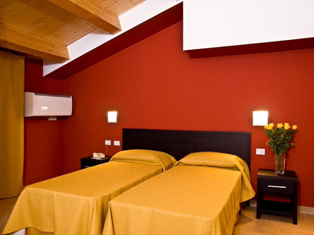 アウグスタにあるCasepicarmo Guest Houseの赤い壁のドミトリールーム ベッド2台