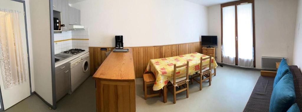 une cuisine avec une table et des chaises et une cuisine avec une cuisinière dans l'établissement Résidence Artigalas - Appartement 4 couchages dans le centre de Barèges MAE-6944, à Barèges