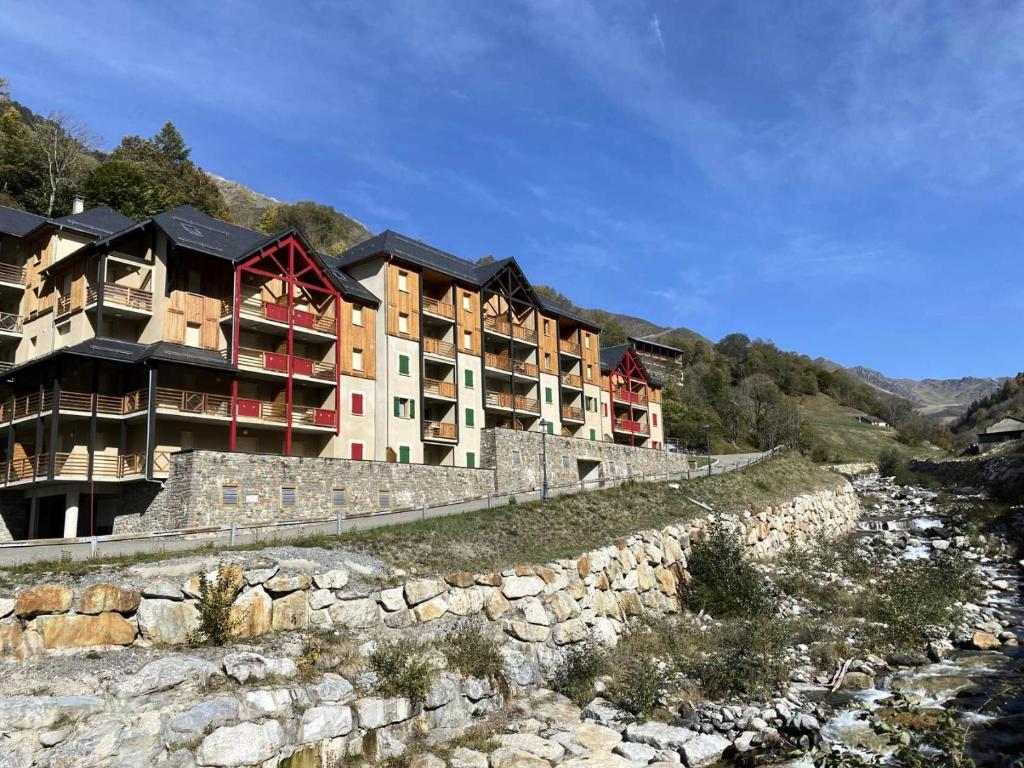 a building on a hill next to a rock wall at Résidence Bois De Marie - 2 Pièces pour 5 Personnes 724 in Barèges