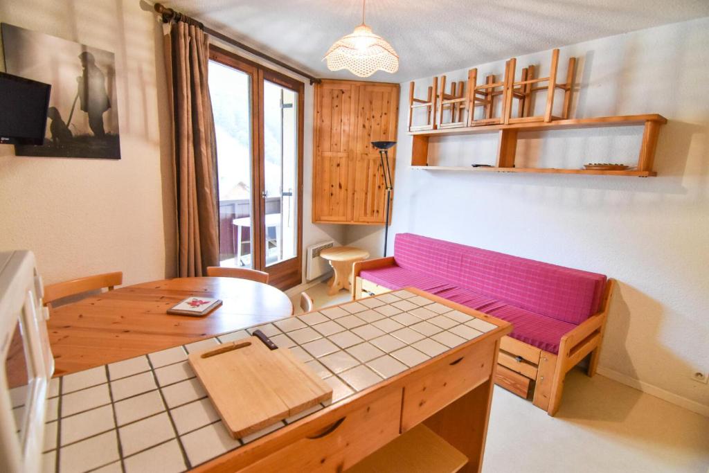 a living room with a purple couch and a table at Residence Le Thymel - Studio pour 3 Personnes 14 in Valloire