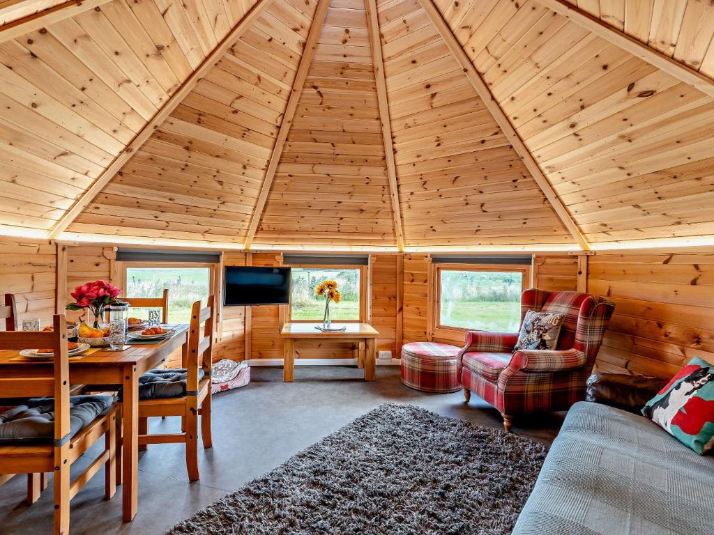a cabin with a wooden ceiling with a table and chairs at 1 Bed in Biggar 91248 in Libberton