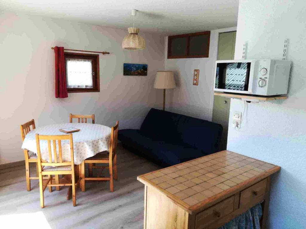 uma sala de estar com uma mesa e um sofá em Résidence La Croix Du Sud - Studio pour 4 Personnes 14 em Valloire