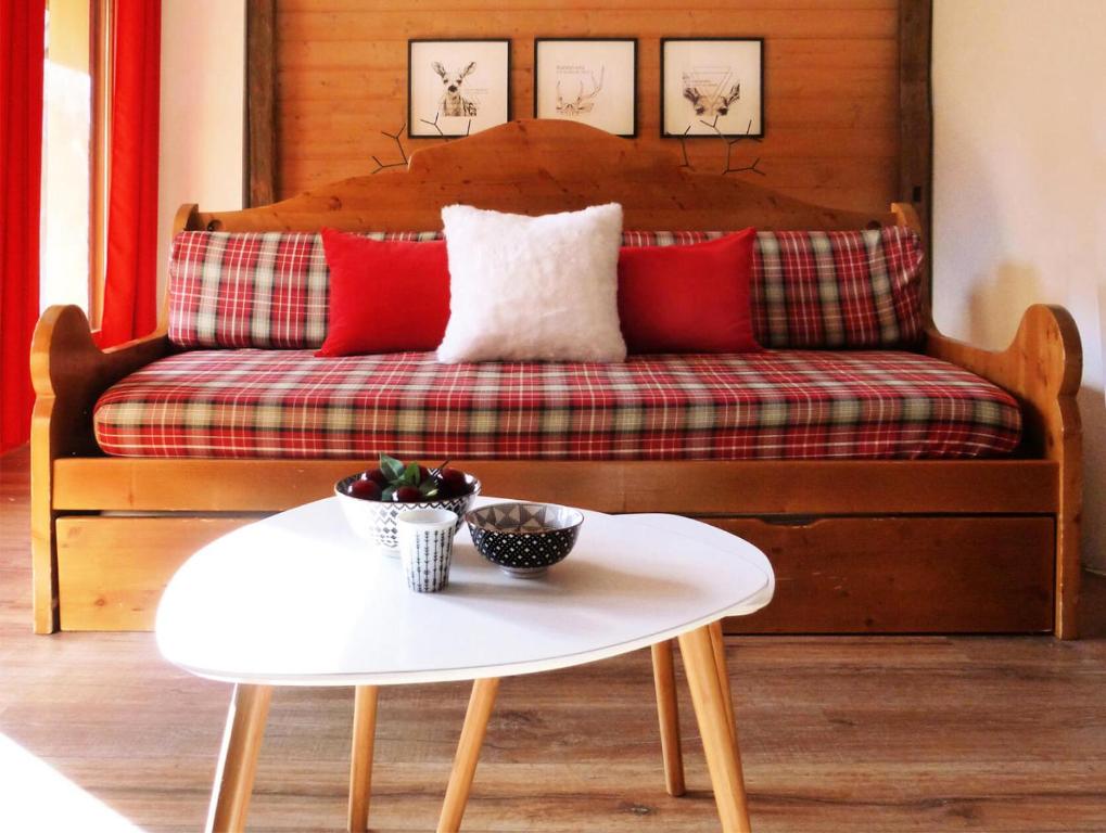 a couch with red pillows and a white table at Résidence Les Fermes Du Planet - 4 Pièces pour 8 Personnes 94 in Valloire