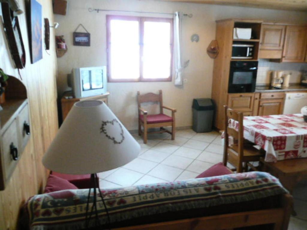 uma sala de estar com um sofá e uma mesa em Chalet Les Aiguilles - Pièces 34 em Valloire