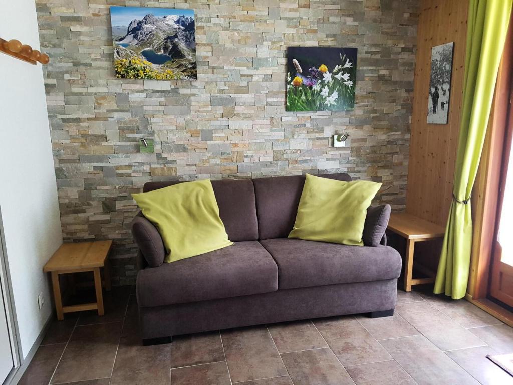 a couch with two yellow pillows in a living room at Résidence La Croix Du Sud - Studio pour 4 Personnes 84 in Valloire
