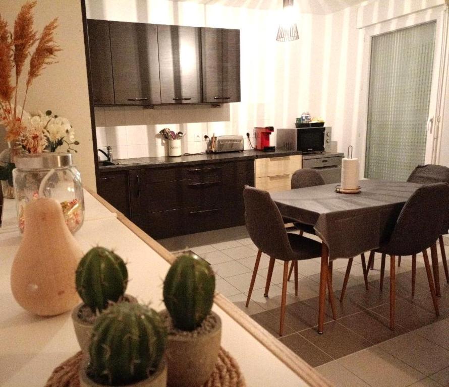 a kitchen with a table with chairs and a dining room at Superbe appartement ,6 pers, proche de Paris, dans résidence privée , parking et WIFI gratuits! ! in Vitry-sur-Seine