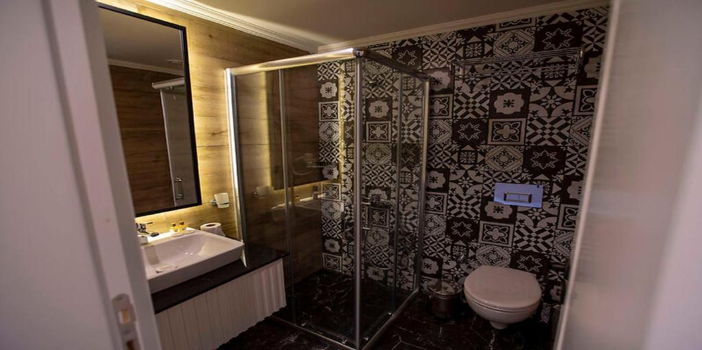 a bathroom with a shower and a toilet and a sink at MIR'AMOR GARDEN Resort Hotel-ALL INCLUSIVE in Antalya