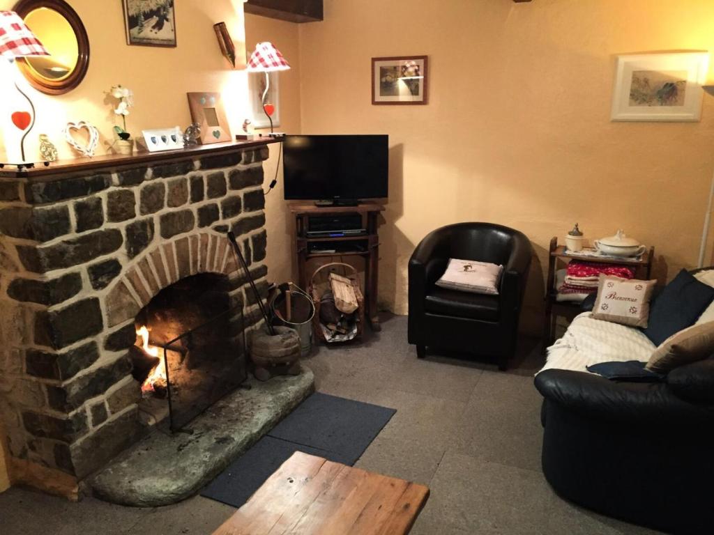 a living room with a brick fireplace and a tv at Résidence Le Moulin Benjamin - Chalets pour 8 Personnes 74 in Valloire