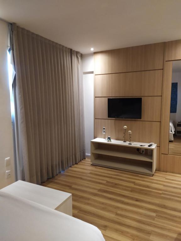 baño grande con bañera y TV en Studio Moderno bem localizado en Feira de Santana