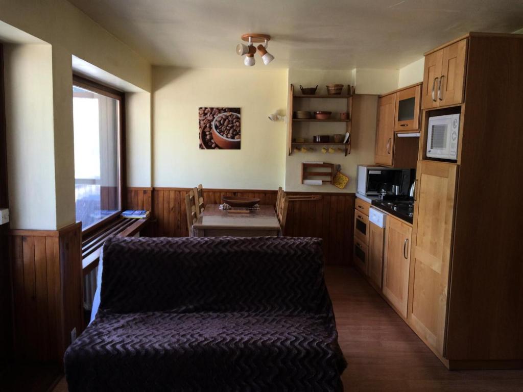 - une cuisine avec des placards en bois et un canapé dans l'établissement Residence Galibier - 2 Pièces pour 5 Personnes 94, à Valloire