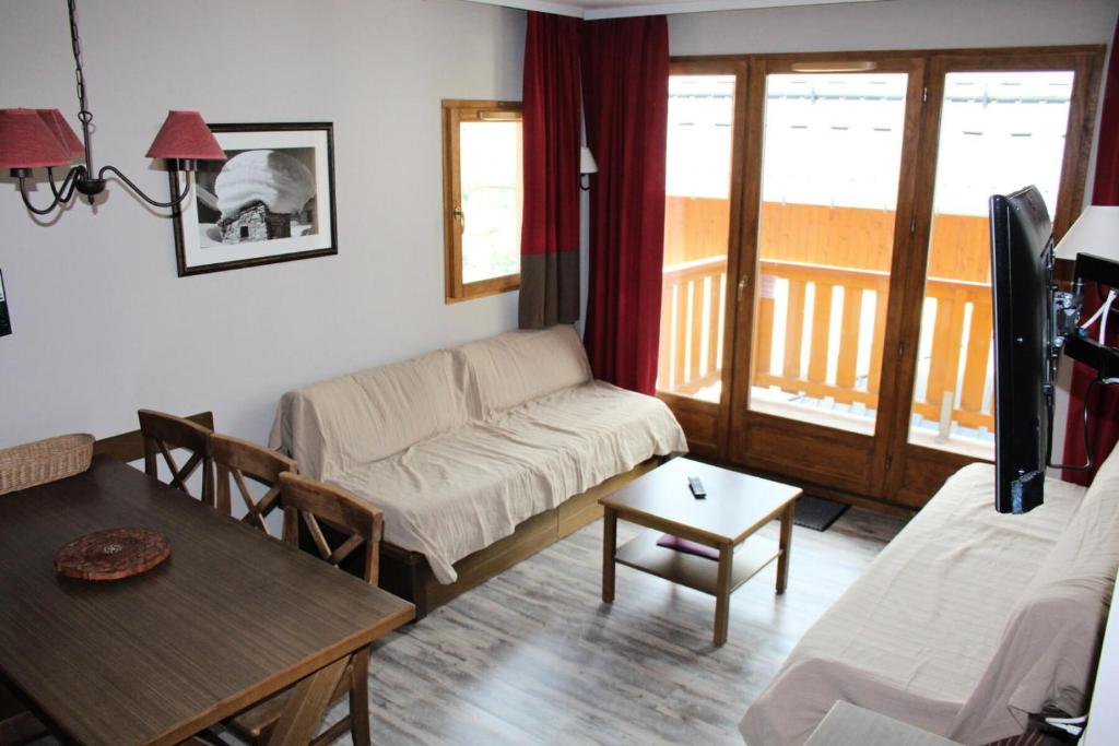 a living room with a couch and a table at Les Chalets Valoria - 3 Pièces pour 6 Personnes 24 in Valloire