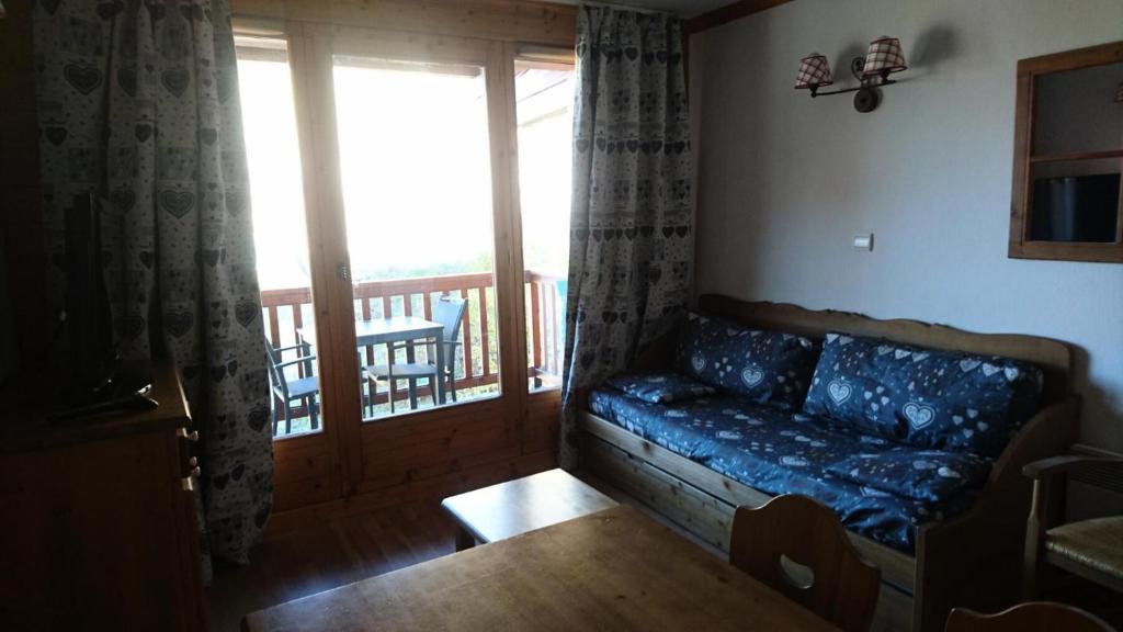 a living room with a couch and a balcony at Edelweiss Chalets De La Vallee D'or - 2 Pièces pour 4 Personnes 34 in Valloire