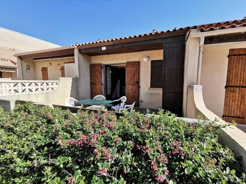 une maison avec une table et des chaises sur le balcon dans l'établissement Résidence Grande Bleue - VILLA T2 MEZZANINE 6 couchages PORT LEUCATE. Réf: 3GB_167 MAE-4664, à Port-Leucate