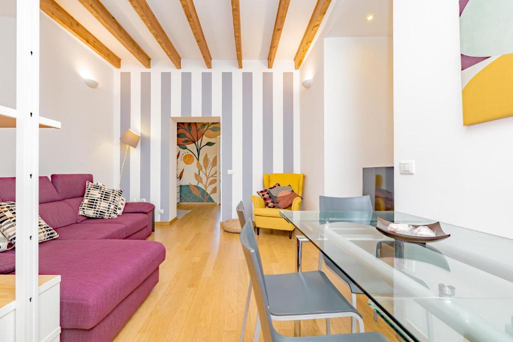 een woonkamer met een paarse bank en een glazen tafel bij Casa Navigli - Cozy Apartment in Milaan